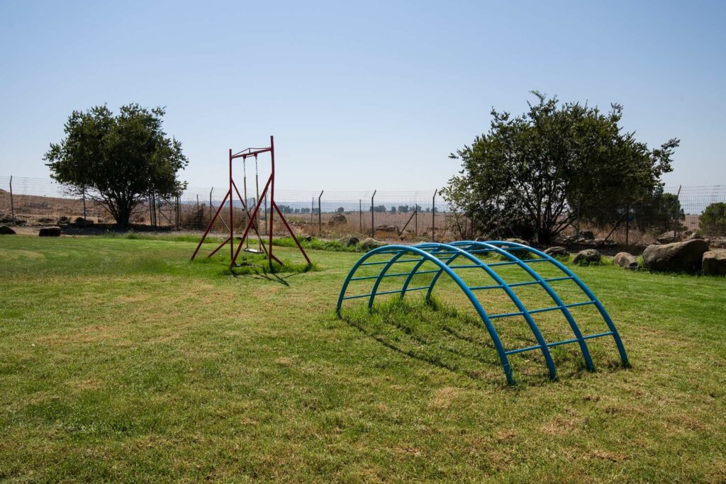 חצר עם דשא ומתקנים לילדים 