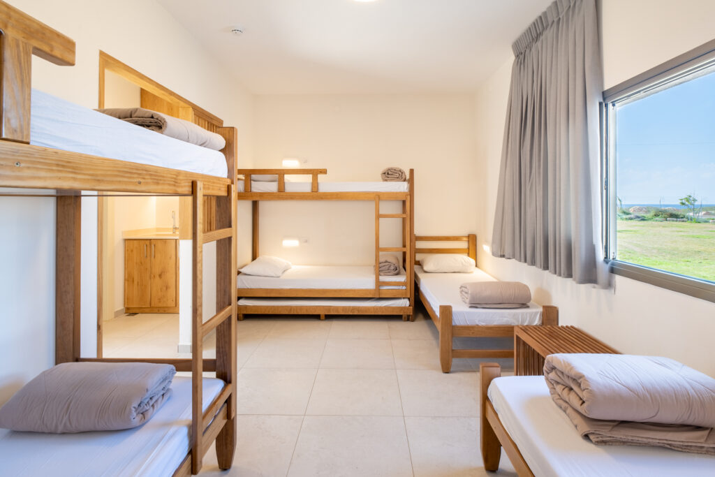 פנים חדר בבית ספר שדה אכזיב. מיטות קומותיים ונוף לים 