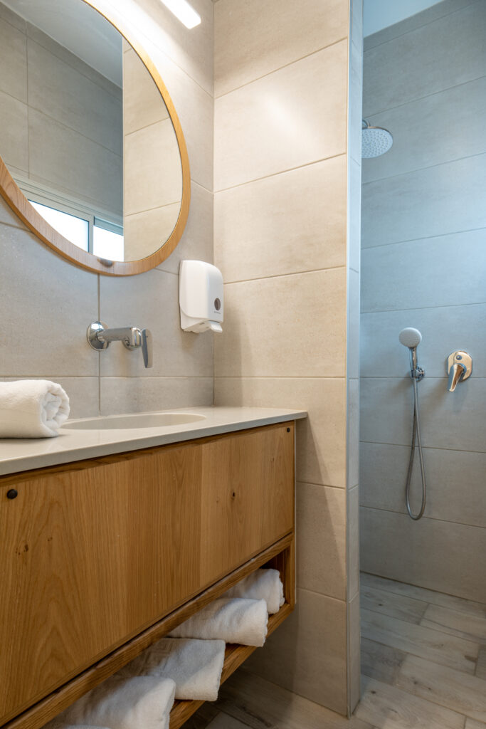 מקלחת בבית ספר שדה אכזיב, מבט דרך המבואה והכיור ורואים את הטוש במקלחת 