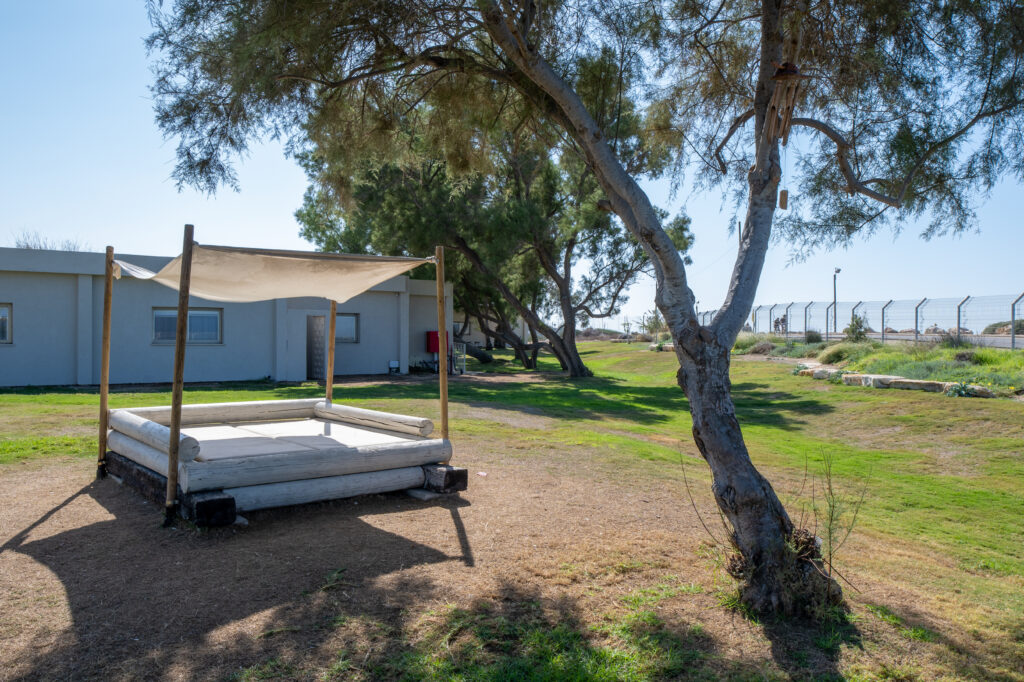 מתחם רביצה עם נוף לים, ישיבה מוצלת עם מזרון במדשאה גדולה 