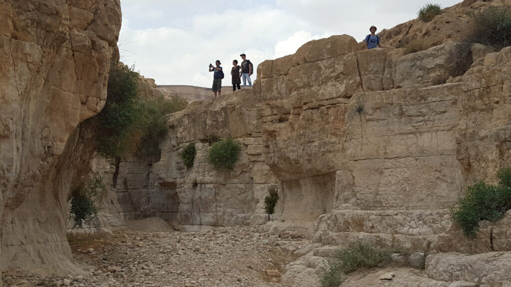 אנשים מטיילים מעל ואדי ללא מים, 
