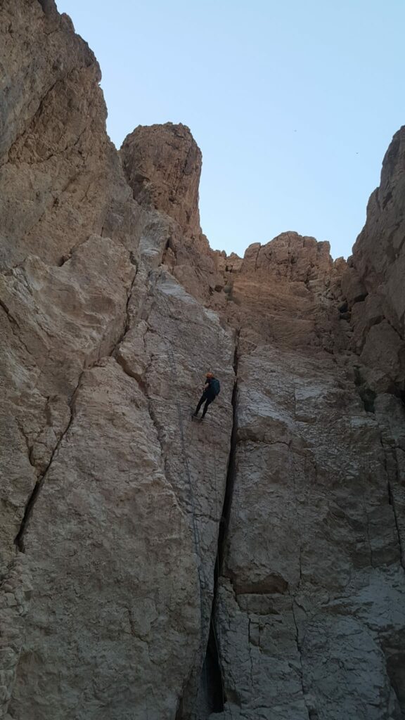 מבט מלמטה לעבר מטייל שעושה סנפלינג בנחל תמרים 