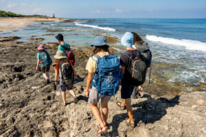 תמונת מטיילים בחוף אכזיב מאחור