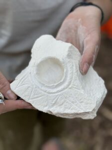 יד מחזיקה חרס בפעילות מלאכות קדומות בטבע