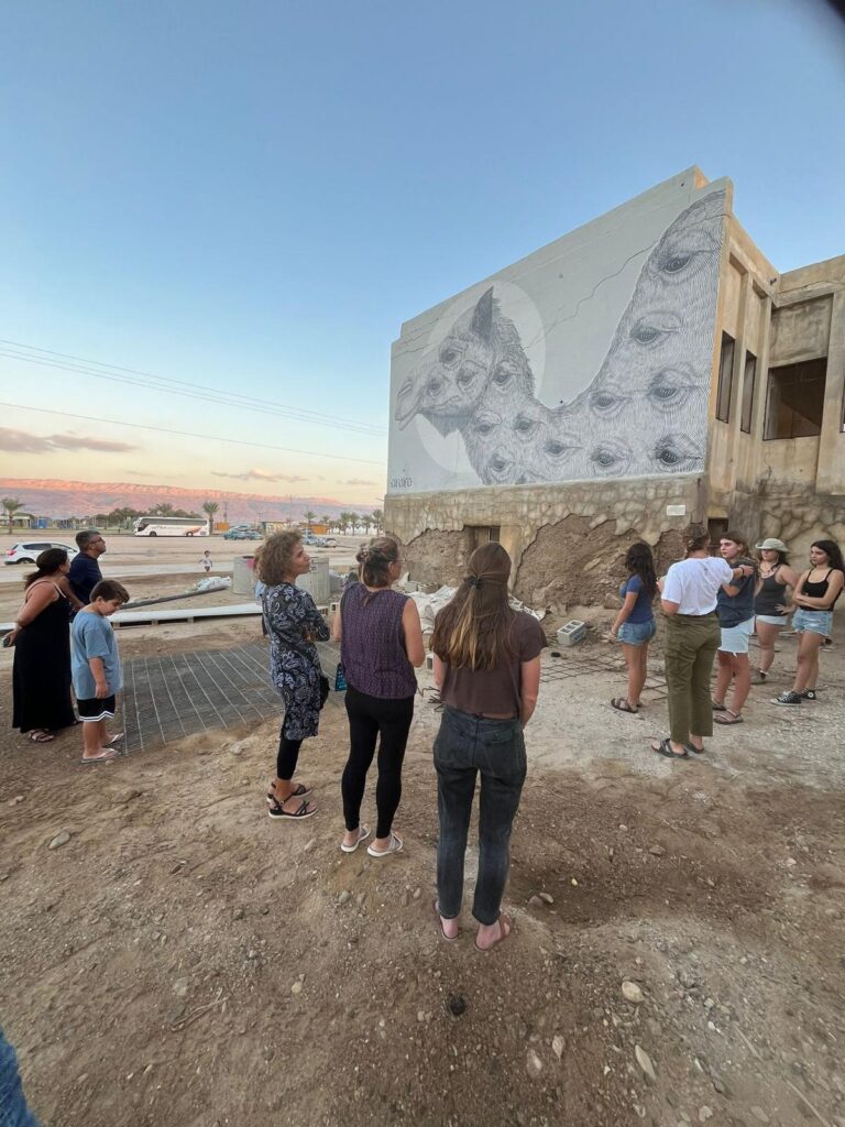 מטיילים מול מבנה עם ציור גרפיטי בצפון ים המלח, גלריה 430 