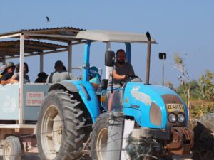 תמונה מלפנים של מטיילים בנסיעה בטרקטור בטיול במעגן מיכאל