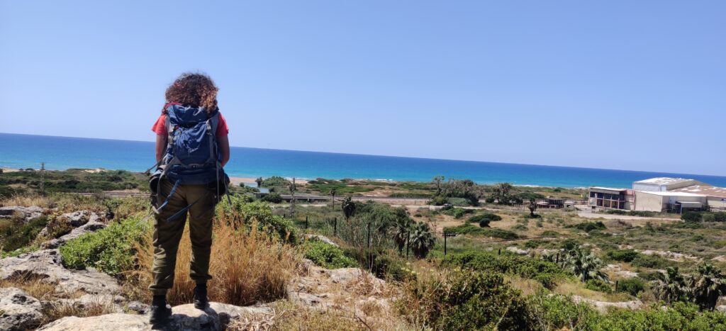 מטיילת בחרבת כרתא בתצלום מהגב מסתכלת על הנוף והים 