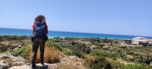 מטיילת בחרבת כרתא בתצלום מהגב מסתכלת על הנוף והים