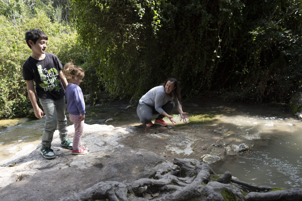 אמא וילדיה משכשכים במים בנחל השופט