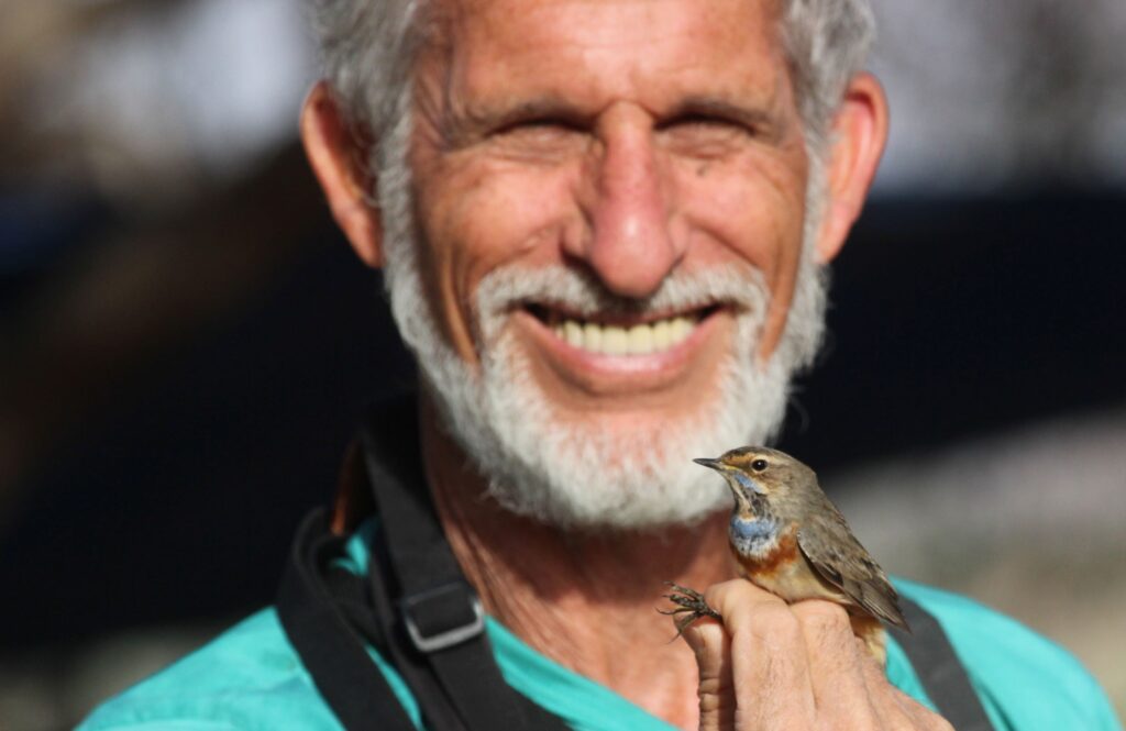 שלמה קרמר עם ציפור בתקריב בפארק הצפרות באילת 