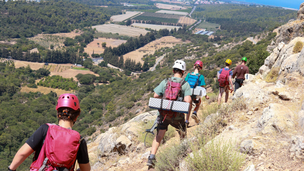 ילדים במחנה קיץ גליל בטיול בשביל ומתחתם נוף גלילי 