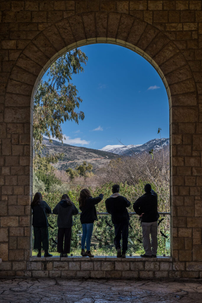 צילום מהגב של מטיילים בבית אוסישקין מסתכלים לעבר הגולן 