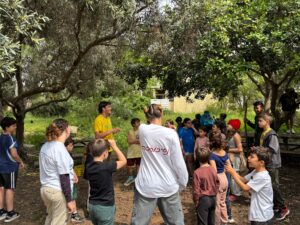 מעגל ילדים ומדריכים בפעילות בחוץ בבית ספר שדה חוף כרמל בזמן מלחמה